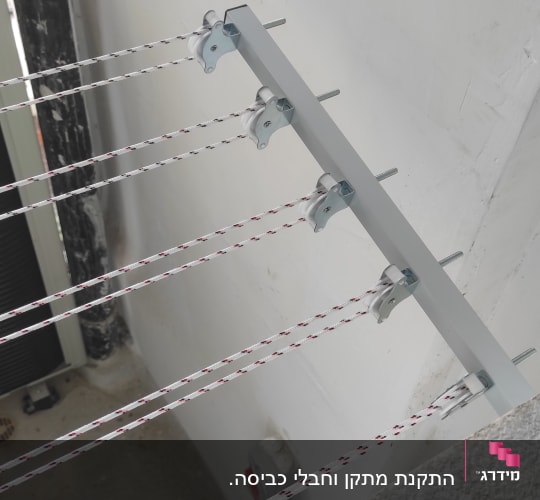 חבלי כביסה מותקנים על קיר עם תופסנים מתכתיים
